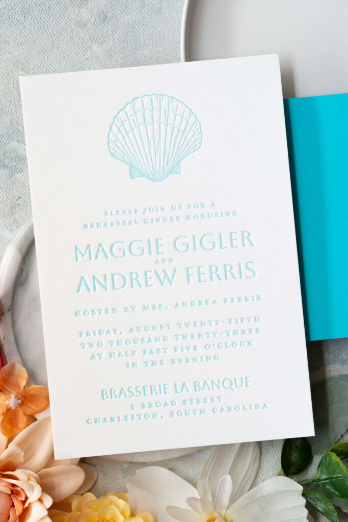 Letterpress welcome dinner invitation with a seashell illustration at the top of the card.